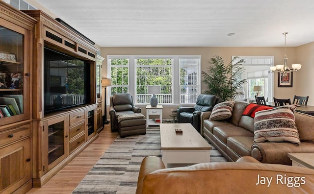 5702 Copper Sands Run Unit 101, Fruitport, MI 49415 - living room with light wood-type flooring, a chandelier, and plenty of natural light