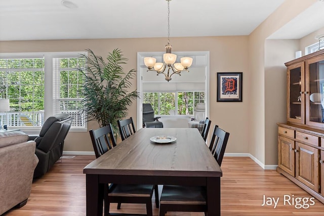 5702 Copper Sands Run Unit 101, Fruitport, MI 49415 - dining area with a chandelier, light wood-style flooring, and baseboards