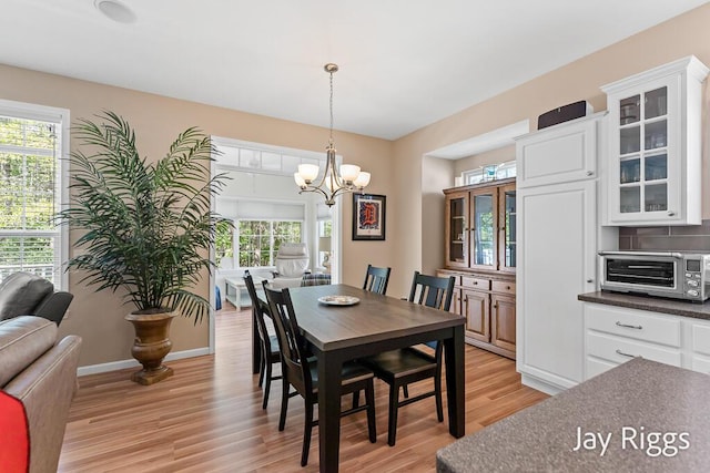 5702 Copper Sands Run Unit 101, Fruitport, MI 49415 - dining area featuring light wood-style flooring, healthy amount of natural light, a chandelier, and baseboards