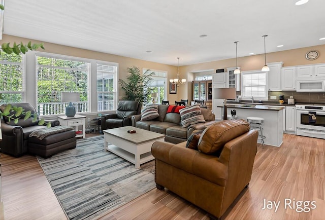 5702 Copper Sands Run Unit 101, Fruitport, MI 49415 - living room with a chandelier, recessed lighting, and light wood-style flooring