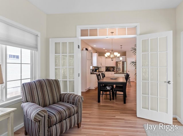 5702 Copper Sands Run Unit 101, Fruitport, MI 49415 - living area featuring a chandelier, plenty of natural light, and light wood finished floors