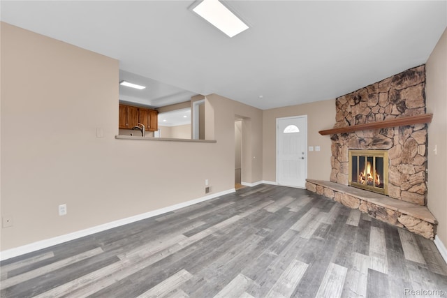 21608 Barton St, Saint Clair Shores, MI 48081 - unfurnished living room with a fireplace, wood finished floors, and baseboards
