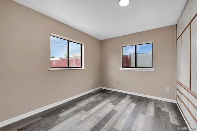 21608 Barton St, Saint Clair Shores, MI 48081 - unfurnished bedroom with dark wood-type flooring, multiple windows, and baseboards