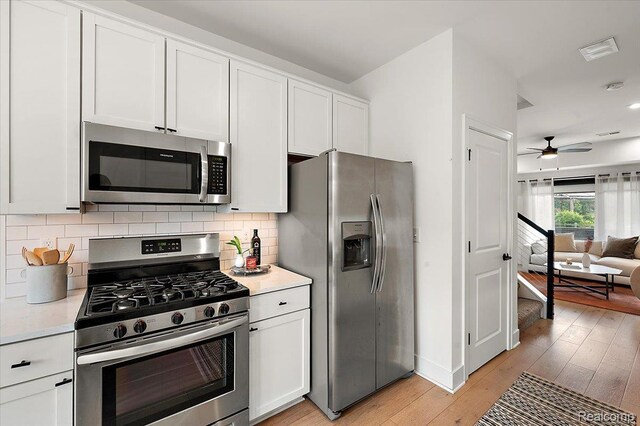 3303 Cochrane, Detroit, MI 48208 - kitchen with stainless steel appliances, light wood-type flooring, white cabinets, a ceiling fan, and decorative backsplash