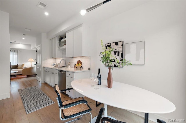 3303 Cochrane, Detroit, MI 48208 - kitchen featuring a sink, stainless steel dishwasher, light countertops, tasteful backsplash, and white cabinets