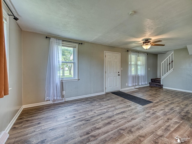22933 Monterey Dr, Woodhaven, MI 48183 - foyer with wood finished floors, a textured ceiling, baseboards, stairway, and a ceiling fan