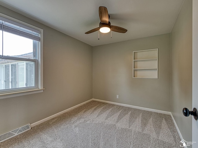 22933 Monterey Dr, Woodhaven, MI 48183 - spare room featuring carpet floors, baseboards, a ceiling fan, and built in shelves