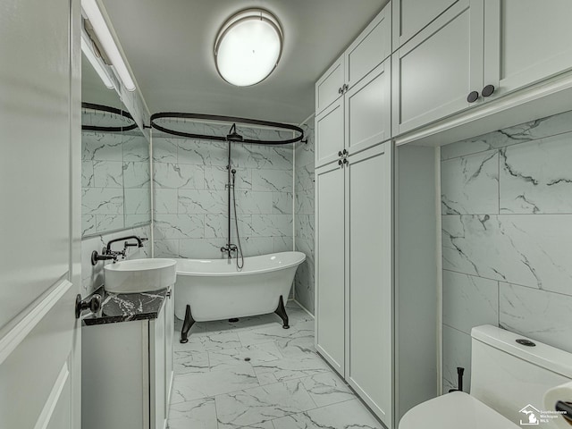 22933 Monterey Dr, Woodhaven, MI 48183 - bathroom with marble look tile flooring, tile walls, a freestanding bath, vanity, and toilet