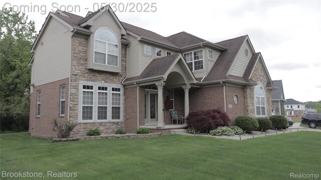 13961 Cobblestone Creek Dr, Belleville, MI 48111 - view of front of property featuring stone siding, a front yard, roof with shingles, and a porch