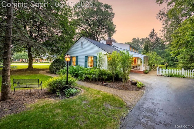 18410 Fermanagh Ct, Northville, MI 48168 - view of front facade with driveway, a chimney, and covered porch
