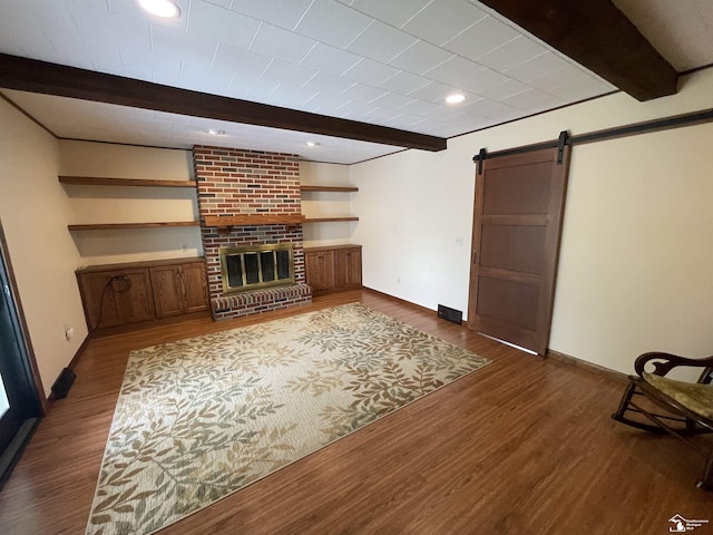 8263 Westwood St, Ida, MI 48140 - unfurnished living room featuring beamed ceiling, a barn door, dark wood-style flooring, baseboards, and a brick fireplace