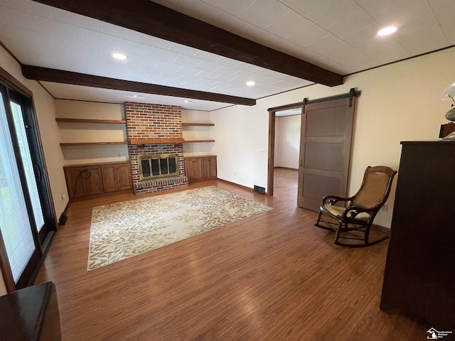 8263 Westwood St, Ida, MI 48140 - unfurnished living room featuring a barn door, baseboards, healthy amount of natural light, beam ceiling, and wood finished floors
