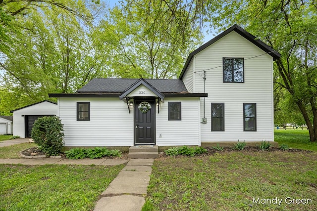 536 E Grant St, Sheridan, MI 48884 - view of front facade with a front yard, a garage, and an outbuilding