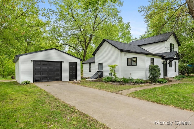 536 E Grant St, Sheridan, MI 48884 - view of property exterior with an outdoor structure, a garage, a yard, a shingled roof, and driveway