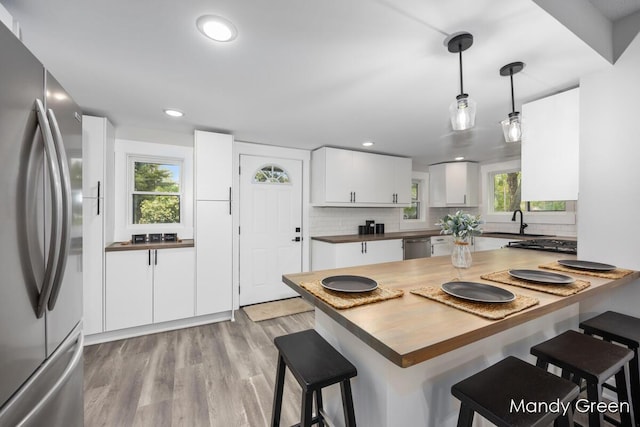 536 E Grant St, Sheridan, MI 48884 - kitchen featuring stainless steel appliances, a kitchen bar, backsplash, white cabinetry, and recessed lighting
