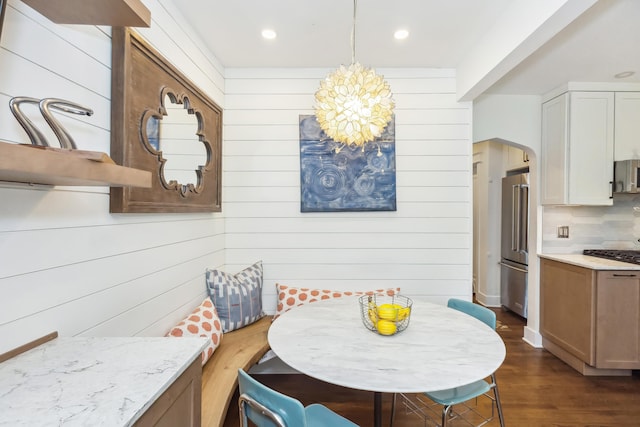 616 S Elm St, Three Oaks, MI 49128 - dining space featuring a chandelier, arched walkways, dark wood-style floors, wood walls, and recessed lighting