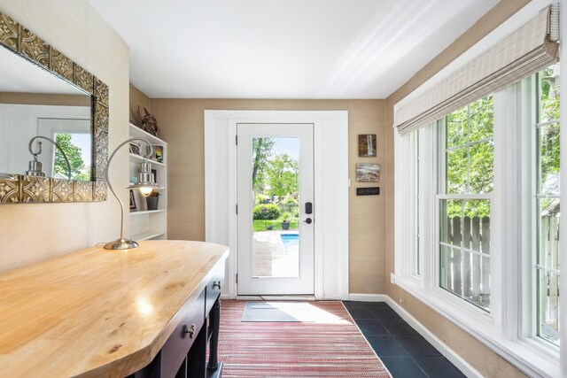 616 S Elm St, Three Oaks, MI 49128 - doorway with healthy amount of natural light, dark tile patterned flooring, and baseboards