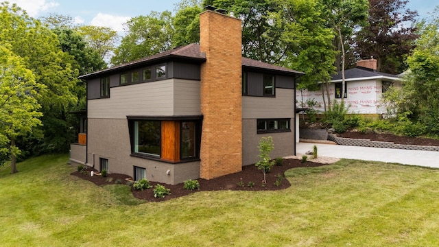 2316 Brockman Blvd, Ann Arbor, MI 48104 - view of side of property with a chimney, a yard, and brick siding