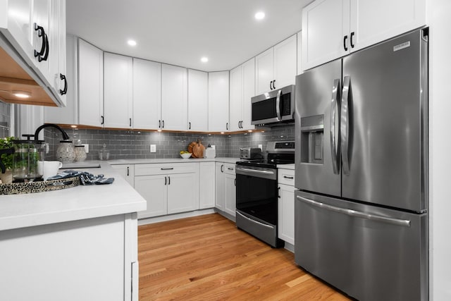2316 Brockman Blvd, Ann Arbor, MI 48104 - kitchen with stainless steel appliances, a sink, light countertops, light wood-style flooring, and backsplash