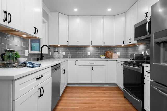 2316 Brockman Blvd, Ann Arbor, MI 48104 - kitchen featuring appliances with stainless steel finishes, a sink, light countertops, decorative backsplash, and white cabinets