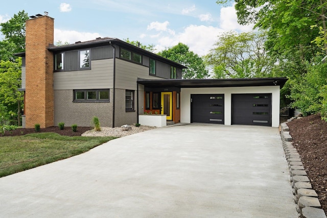 2316 Brockman Blvd, Ann Arbor, MI 48104 - view of front of home with a chimney, a garage, concrete driveway, and brick siding