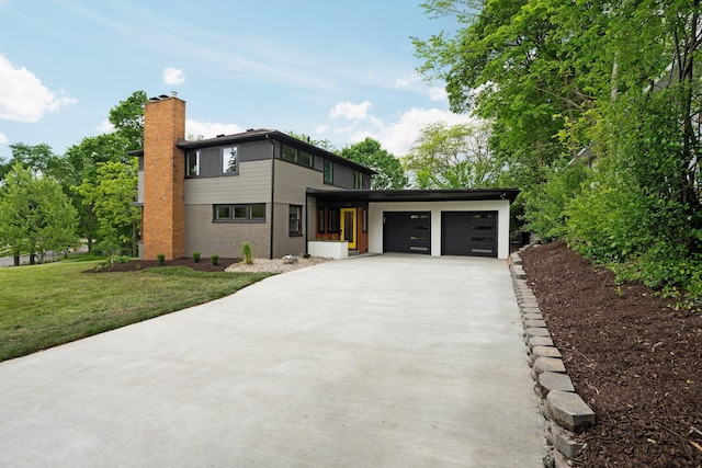 2316 Brockman Blvd, Ann Arbor, MI 48104 - view of front of home with a garage, driveway, a front lawn, and a chimney