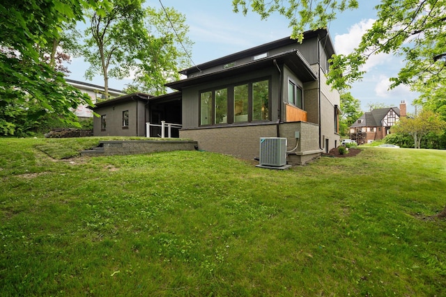 2316 Brockman Blvd, Ann Arbor, MI 48104 - rear view of property featuring cooling unit, brick siding, and a yard