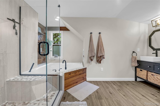 1104 James K Blvd, Pontiac, MI 48341 - full bathroom featuring vanity, a bath, wood finished floors, vaulted ceiling, and a stall shower