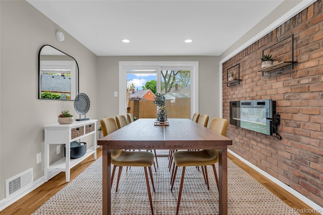 1104 James K Blvd, Pontiac, MI 48341 - dining space with light wood-type flooring, a brick fireplace, baseboards, and recessed lighting