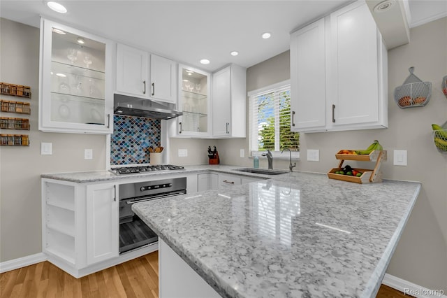 1104 James K Blvd, Pontiac, MI 48341 - kitchen with wall oven, under cabinet range hood, a sink, stainless steel gas stovetop, and a peninsula