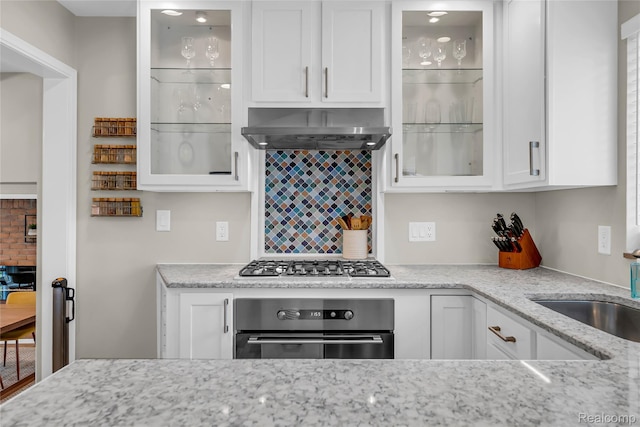 1104 James K Blvd, Pontiac, MI 48341 - kitchen with appliances with stainless steel finishes, wall chimney range hood, white cabinetry, tasteful backsplash, and light stone countertops