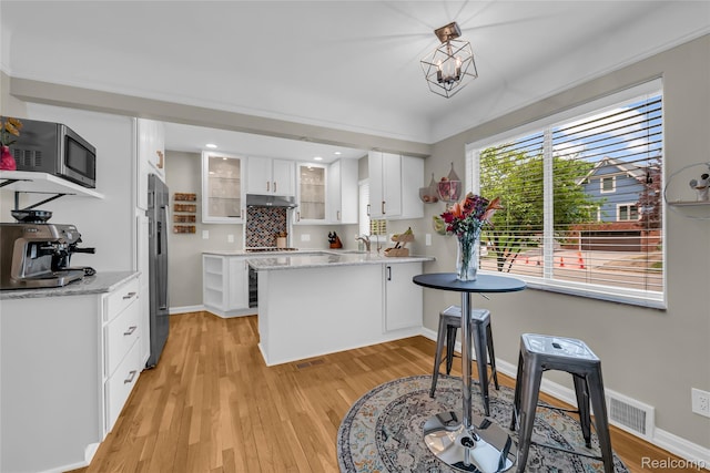 1104 James K Blvd, Pontiac, MI 48341 - kitchen with stainless steel appliances, white cabinetry, a sink, light wood-style flooring, and baseboards