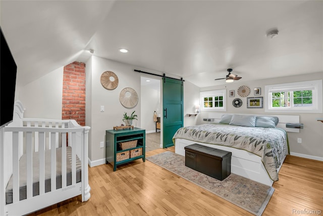 1104 James K Blvd, Pontiac, MI 48341 - bedroom featuring a barn door, light wood finished floors, baseboards, lofted ceiling, and a ceiling fan