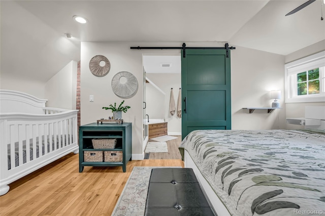1104 James K Blvd, Pontiac, MI 48341 - bedroom with a barn door, vaulted ceiling, light wood-style flooring, recessed lighting, and baseboards
