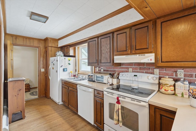 650 N Shore Dr, Crystal, MI 48818 - kitchen with white appliances, under cabinet range hood, light countertops, light wood finished floors, and brown cabinets