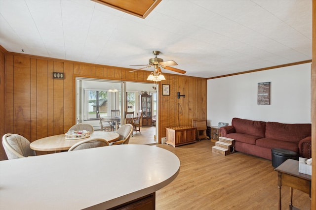 650 N Shore Dr, Crystal, MI 48818 - living room with light wood-style floors, wood walls, crown molding, and ceiling fan