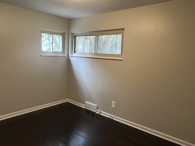 24680 Kenosha St, Oak Park, MI 48237 - spare room featuring baseboards and dark wood-type flooring