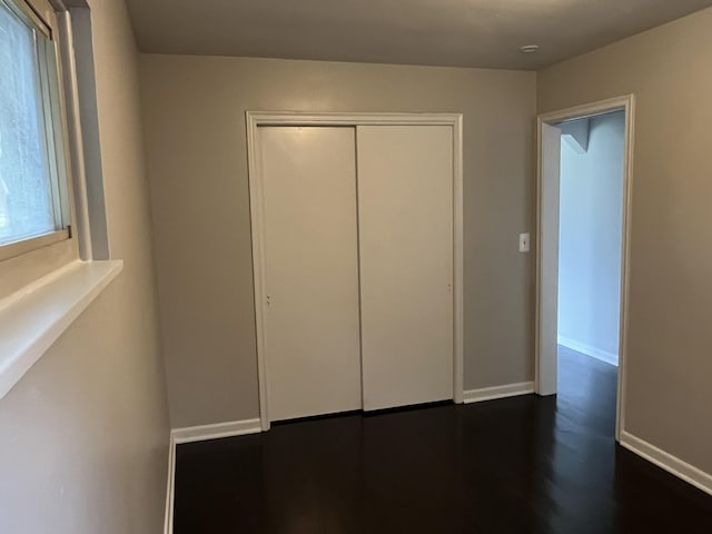 24680 Kenosha St, Oak Park, MI 48237 - unfurnished bedroom featuring a closet, baseboards, and dark wood-style flooring