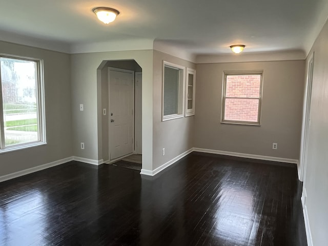 24680 Kenosha St, Oak Park, MI 48237 - empty room featuring arched walkways, dark wood finished floors, and baseboards
