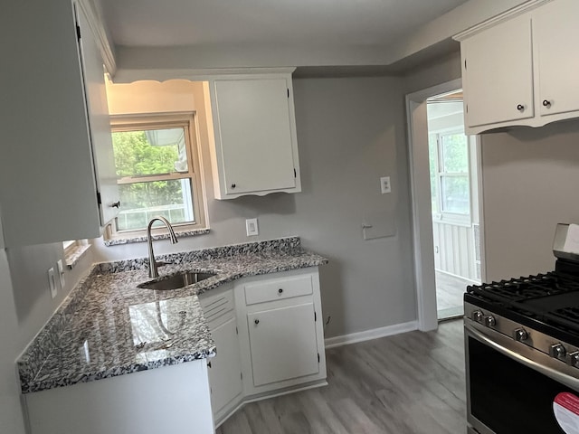 24680 Kenosha St, Oak Park, MI 48237 - kitchen featuring a sink, gas stove, white cabinetry, stone counters, and baseboards