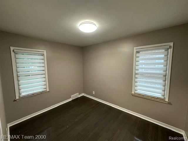 1042 Drexel St, Dearborn, MI 48128 - unfurnished room featuring dark wood finished floors, baseboards, and plenty of natural light
