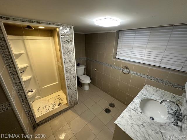 1042 Drexel St, Dearborn, MI 48128 - full bathroom with a stall shower, vanity, tile patterned floors, toilet, and tile walls