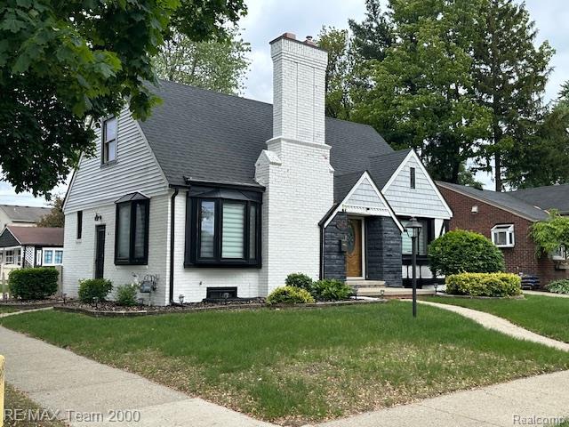 1042 Drexel St, Dearborn, MI 48128 - view of front of house with a chimney, a front yard, brick siding, and a shingled roof