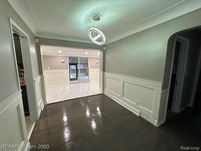 1042 Drexel St, Dearborn, MI 48128 - hall with a decorative wall, a wainscoted wall, arched walkways, and dark wood-type flooring