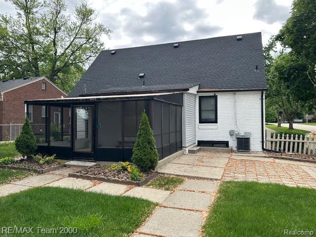 1042 Drexel St, Dearborn, MI 48128 - rear view of house with a sunroom, cooling unit, a shingled roof, and brick siding