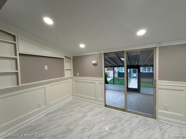 1042 Drexel St, Dearborn, MI 48128 - spare room featuring a decorative wall, built in shelves, wainscoting, light marble finish flooring, and recessed lighting