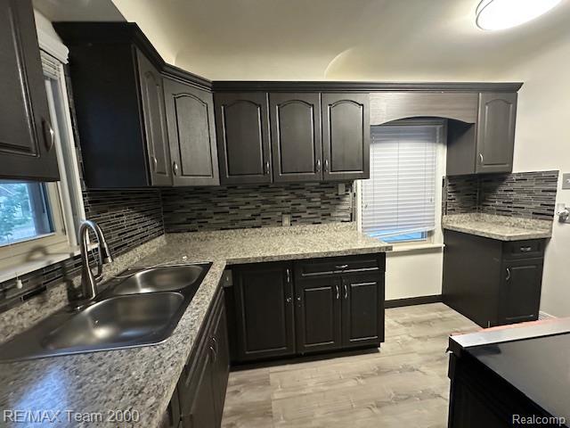 1042 Drexel St, Dearborn, MI 48128 - kitchen with a sink, light wood-style flooring, and tasteful backsplash