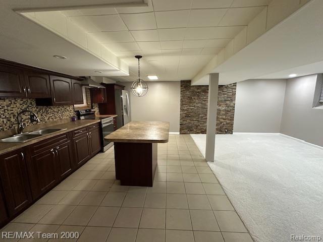 1042 Drexel St, Dearborn, MI 48128 - kitchen featuring appliances with stainless steel finishes, a sink, a kitchen island, light tile patterned floors, and open floor plan