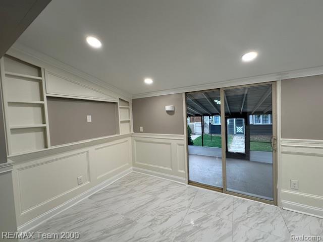1042 Drexel St, Dearborn, MI 48128 - spare room featuring a decorative wall, built in shelves, light marble finish flooring, wainscoting, and recessed lighting