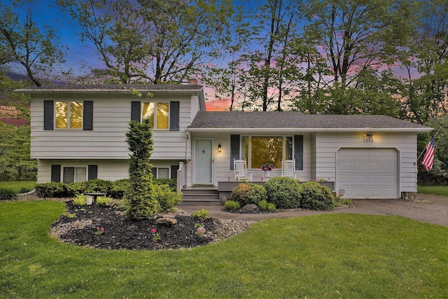 2210 Inglewood Ter, Owosso, MI 48867 - tri-level home with a garage, asphalt driveway, a front lawn, a chimney, and covered porch
